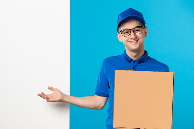 笔记本电脑身着蓝色制服 蓝色披萨 面带微笑的男快递员的正视图服务秘书制服