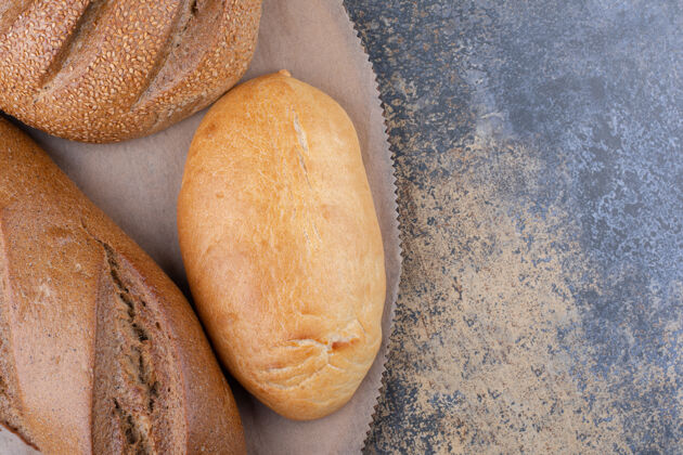 面包皮各式各样的面包类型放在大理石表面的木板上各种餐面包