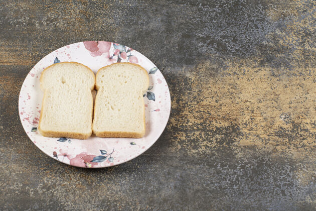 食品两片面包放在五颜六色的盘子里面包房健康早餐