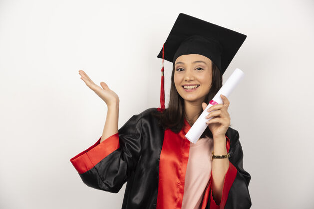 年轻刚毕业的女性 拿着文凭在白色背景上摆姿势学术学生女性