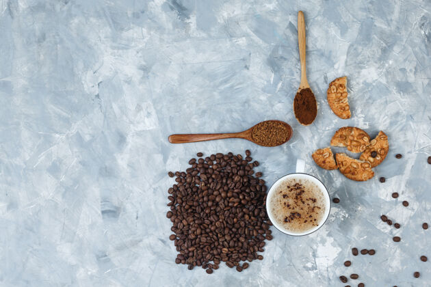 咖啡馆咖啡杯里有饼干 咖啡豆 磨碎的咖啡 背景是灰色的新鲜的乡村的曲奇