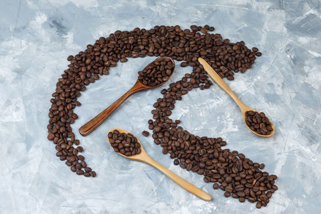 木材把咖啡豆平铺在灰色灰泥背景上的木勺里水平阿拉伯语美食自然