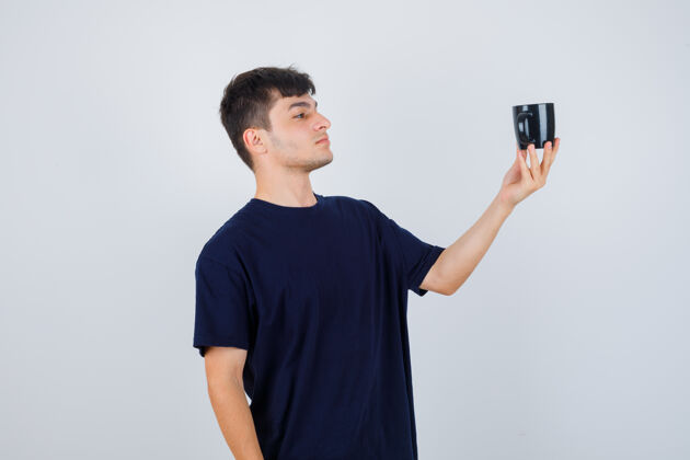 男一幅年轻人穿着黑色t恤看着一杯茶 神情沉思的正面照片思考思考休闲