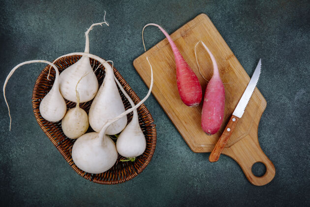 甜菜白色根蔬菜甜菜根在桶上的俯视图 桃红色甜菜根放在木制菜板上 刀子放在绿色的表面上健康美味食物