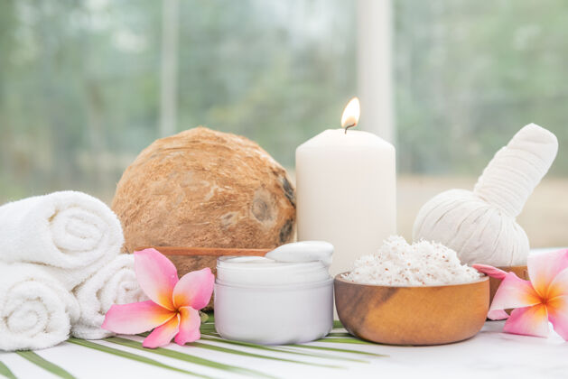 桌子椰子油 热带树叶和新鲜椰子轻木表面的spa椰子产品水果瓶子蜡烛