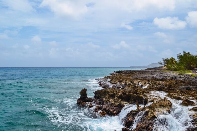 海景美丽的海岸岩石照片 背景是多云的蓝天海洋令人叹为观止水