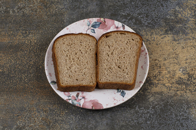 早餐把新鲜黑麦面包片放在五颜六色的盘子里小吃切片切片
