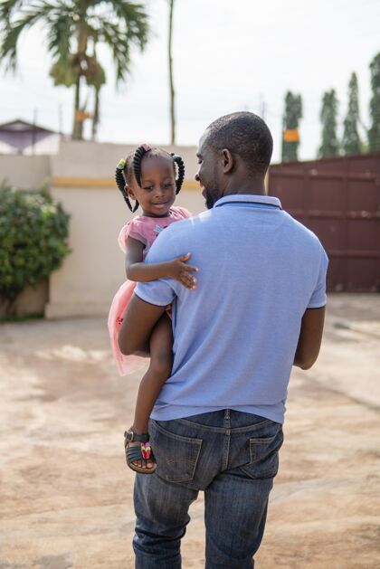 非洲爸爸抱着他的小黑人女孩年轻小可爱