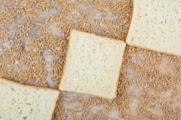 新鲜白面包片和大麦在大理石表面大麦切片小麦