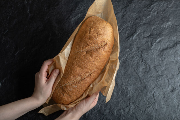 包装拿着包好的新鲜面包的女人自制面包农业
