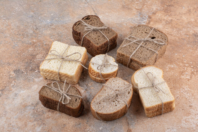 分类各种各样的面包堆在大理石背景上绳索美味面包房