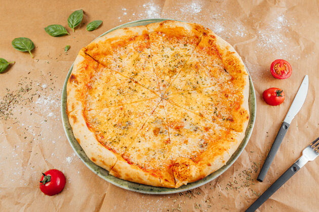 罗勒用叉子和刀子把美味的比萨饼摊平一餐马苏里拉意大利