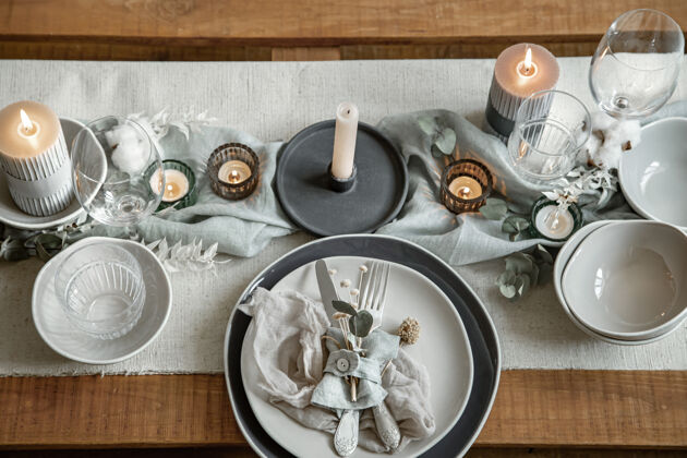 干洗节日餐桌的特写细节 包括一套餐具 一个盘子和烛台上的蜡烛布料盘子衣服