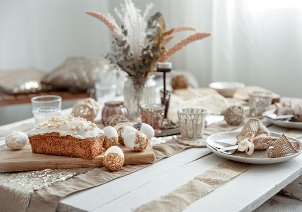 优雅一个节日的桌子与一个美丽的设置 装饰细节 鸡蛋和复活节蛋糕釉面背景蛋糕