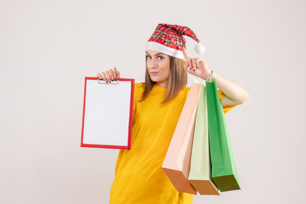 持有年轻女子拿着购物包和纸条上的白色购物圣诞节购物者