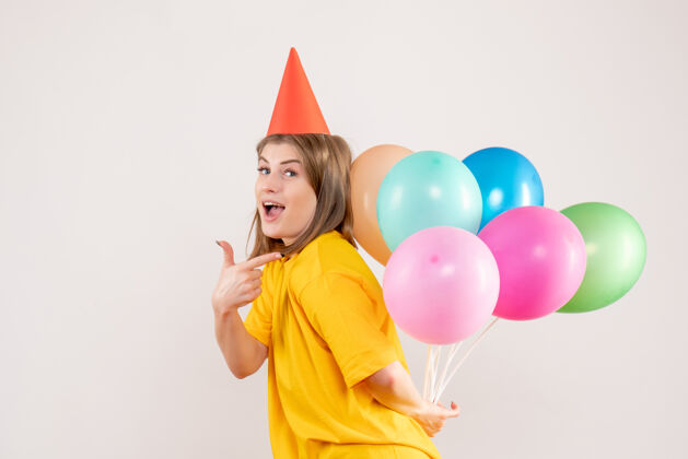 庆祝年轻的女性把彩色的气球藏在白色的背上回来聚会情感
