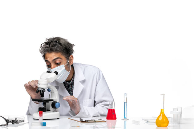 化学前视图穿着白色医疗服的中年科学家正在尝试使用显微镜实验使用专业