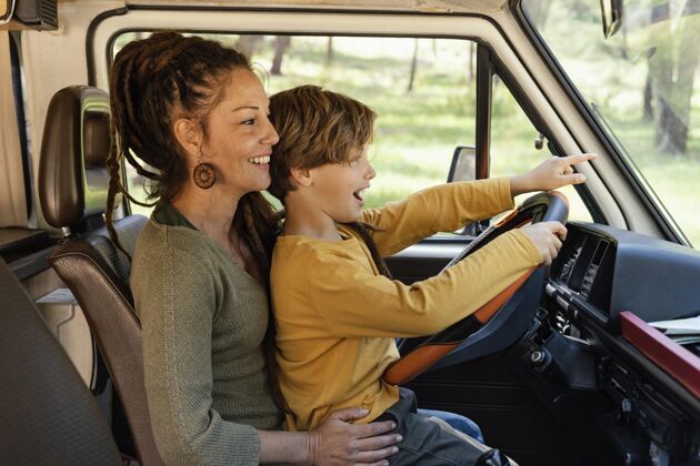 女人侧视图：一个女人抱着儿子开车旅行孩子汽车