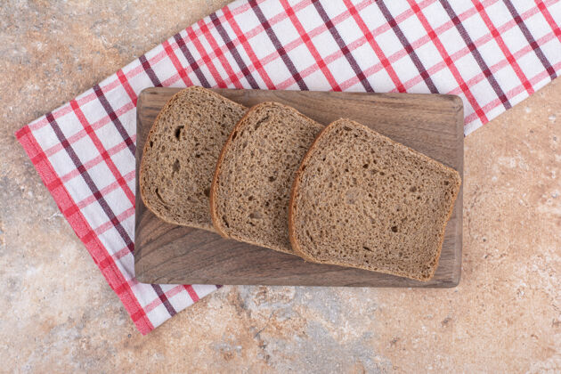 面包用桌布把黑面包片放在木板上谷类食品自制面包房