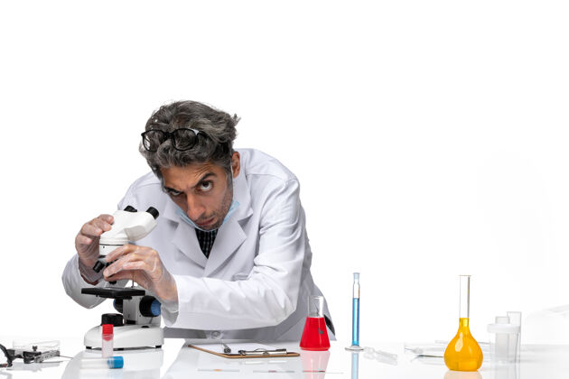 技术人员正面图身着白色医疗套装的中年科学家固定显微镜人工作实验室