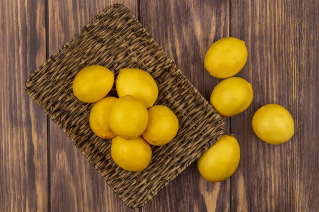 柳条柳条托盘上的柑橘类水果柠檬的俯视图 柠檬被隔离在木墙上厨房景观新鲜