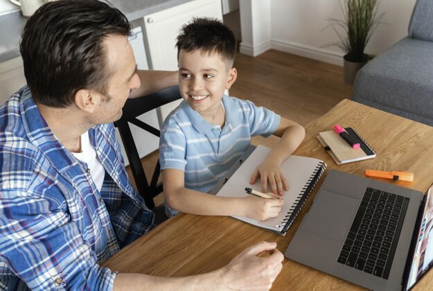 成人中枪的父亲和男孩带着笔记本电脑笔记本电脑一起孩子