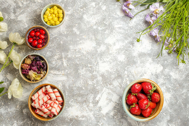 胡椒顶视图新鲜的红色草莓和糖果的白色表面颜色浆果糖果食品顶部盘子