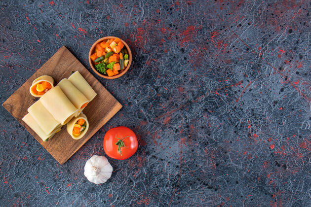 晚餐卡拉马拉塔意大利面 在木板上装满切碎的蔬菜番茄面食通心粉