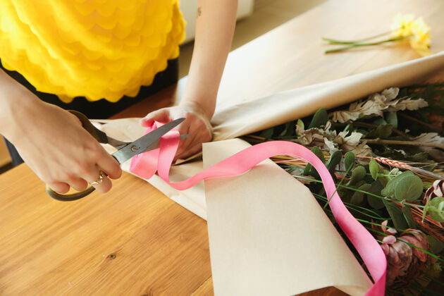 黄麻花店在工作的女人展示如何使花束在家工作的概念近距离室内花店手
