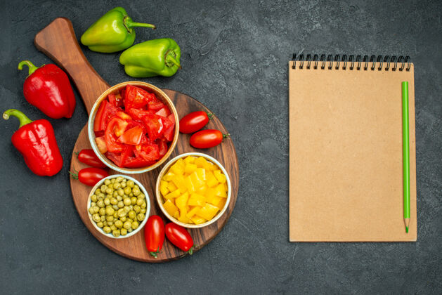 午餐盘子架上的蔬菜碗顶视图 深灰色背景上有蔬菜和便签食物新鲜健康