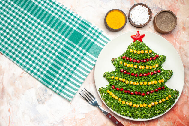 树顶视图美味的蔬菜沙拉在新年树形状与调味品在一个轻背景背景圣诞灯光