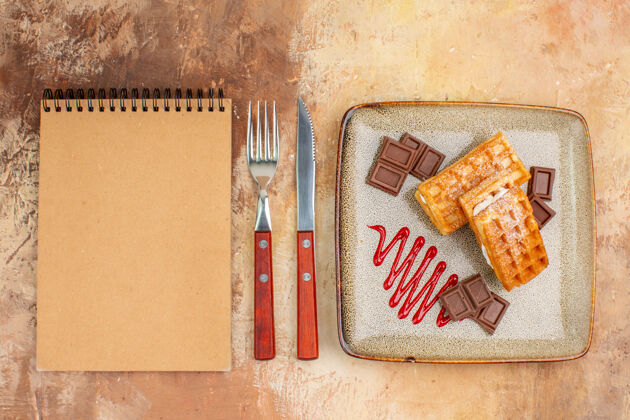 旧的俯瞰美味的华夫饼与巧克力条棕色背景背景甜点交换