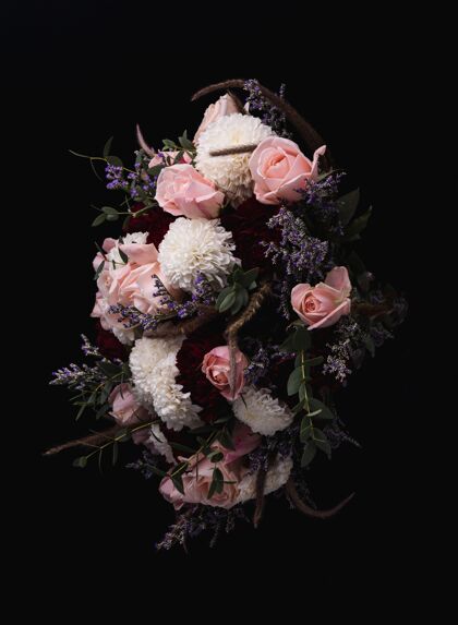 庆祝一束奢华的粉红色玫瑰和白色大丽花的垂直镜头 黑色的背景是红色的大丽花花瓣自然花