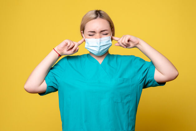 护士正面图女医生穿着医用衬衫 戴着消毒口罩 捂着耳朵 医院科维德大流行的医护人员医疗女性绝育