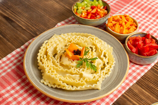 盘子前视图生面团与切片蔬菜在棕色空间蔬菜美食正餐