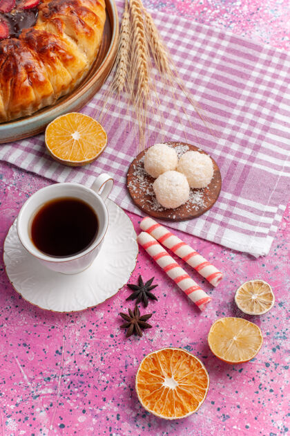 水果顶视图美味的草莓派与一杯茶在明亮的粉红色茶椰子咖啡