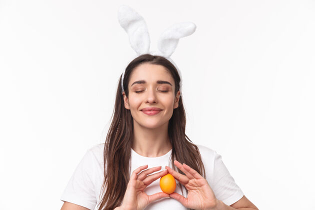 有趣可爱的年轻女子在兔子耳朵里拿着彩蛋商业快乐折扣