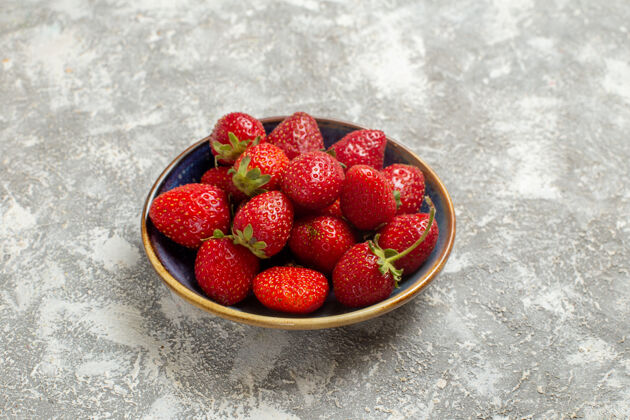 水果正面图新鲜的红色草莓放在盘子里 白色桌上 红色浆果新鲜可食用水果甜点健康