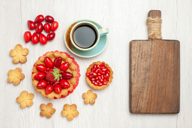 早餐俯瞰白色桌子上的小蛋糕 水果饼干和一杯茶烘焙水果桌子