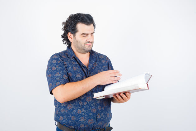 人中年男子穿衬衫翻阅着书 目光集中 正前方前景衬衫男人