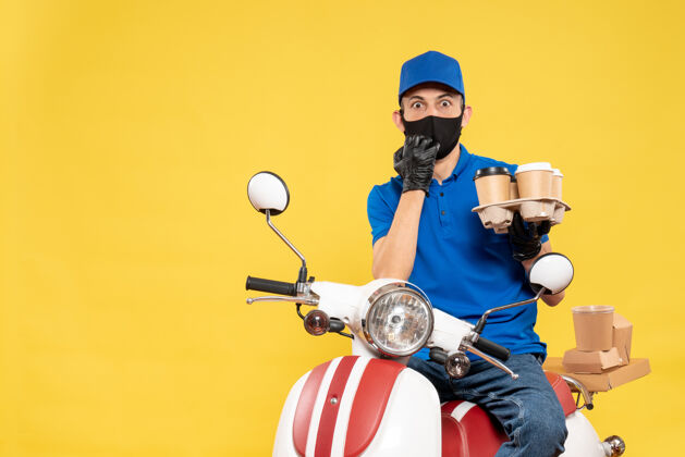 工作正面图身穿蓝色制服的男信使 骑着咖啡 骑着黄色的自行车工作工作递送服务大流行病毒摩托车工作男人