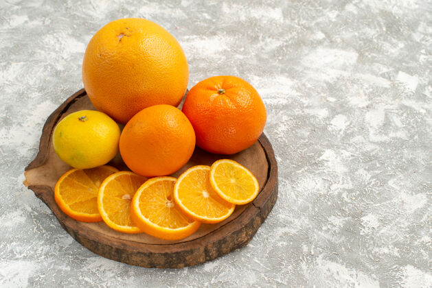 景观水果前视图新鲜的橘子和橘子在浅白色的背景上柑橘异国情调的热带新鲜水果前庭水果生的橙子