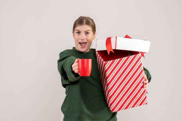快乐前视图年轻女性 圣诞礼物和一杯茶茶礼物微笑