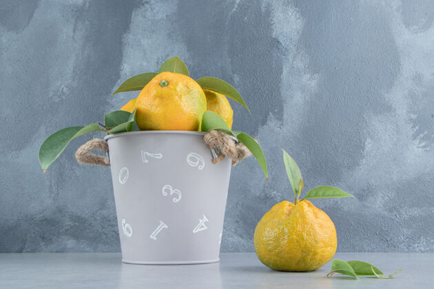多汁一个装满橘子的小桶在大理石上美味柑橘饮食