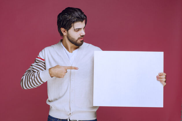 活动一个男人拿着一块空白的创意板 指着它想引起注意工人员工男性