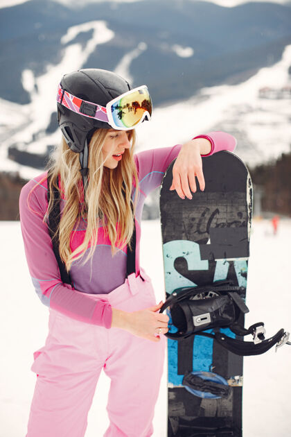 运动服穿着滑雪板套装的女人在山上手拿滑雪板的运动员在地平线上关于运动的概念滑雪板雪板
