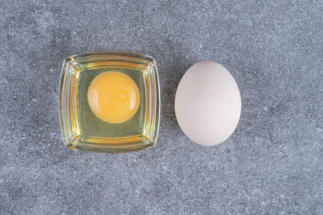 生的生的蛋黄鸡蛋放在大理石表面家禽未经烹调的鸡蛋
