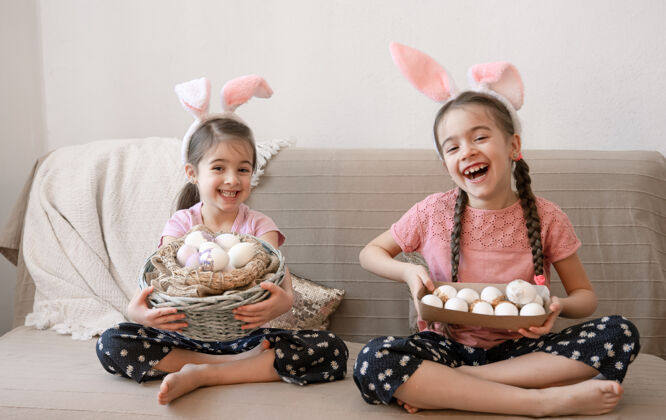 准备有兔子耳朵的快乐小姐妹们 还有复活节彩蛋庆祝鸡蛋孩子
