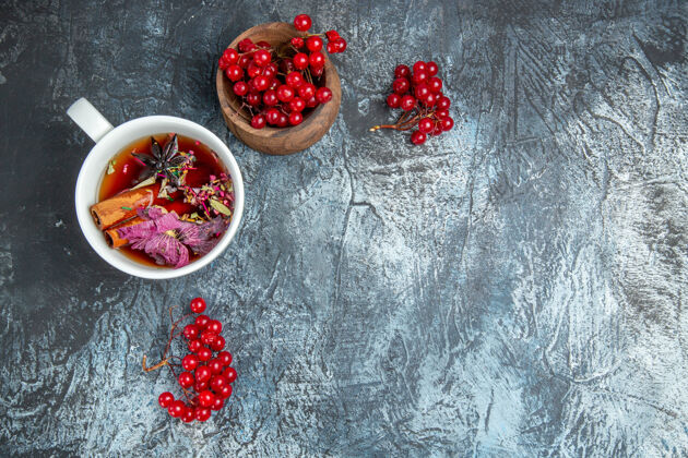 食用水果一杯茶的顶视图 在黑暗的表面上有红色的小红莓蔓越莓茶野生