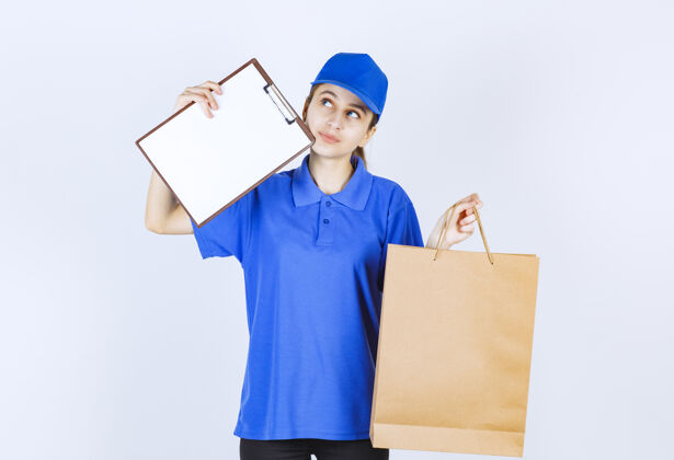 工人穿着蓝色制服的女孩手里拿着一个纸板购物袋和一张顾客名单员工人服装